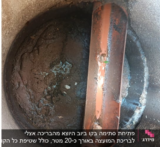 צינור כתום בתוך בור עם בוץ ולכלוך
